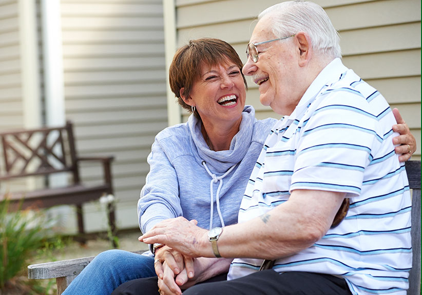 Elderly couple holding hands and laughing