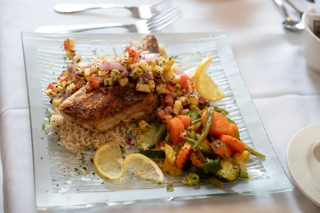 plate of food, salmon on a bed of rice with vegetables