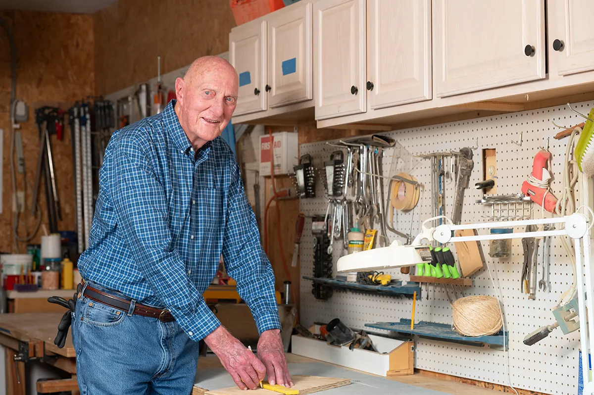 man working at a workbench in a woodshed