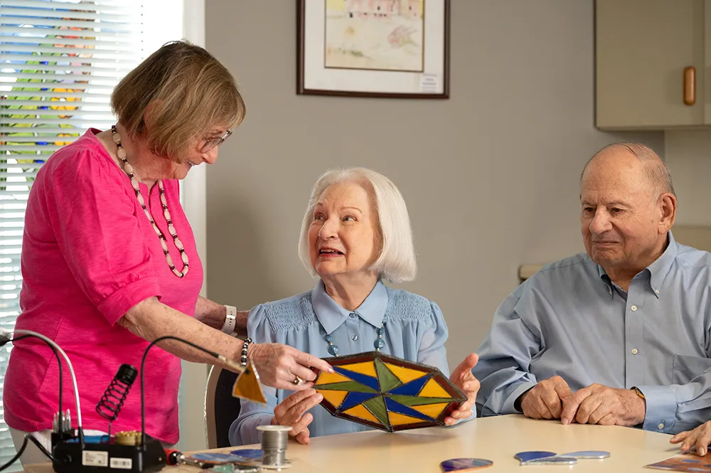 a woman and a man getting instructions on how to make stained glass items