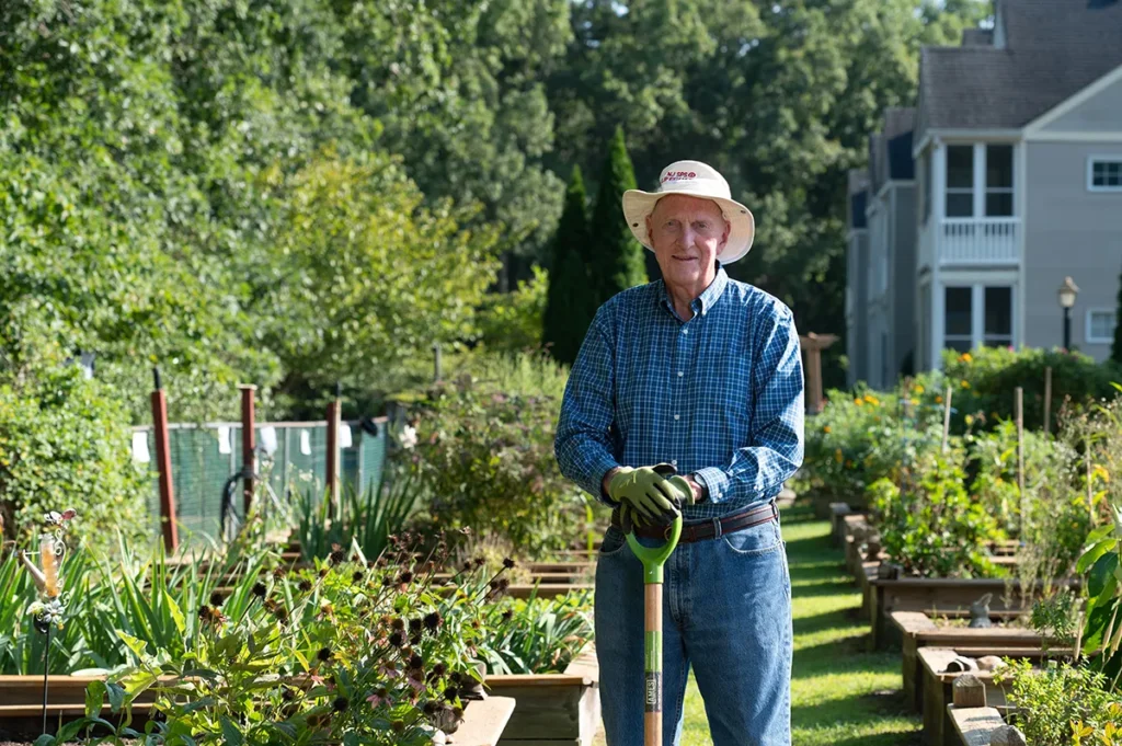 man with a shovel posing in the garden