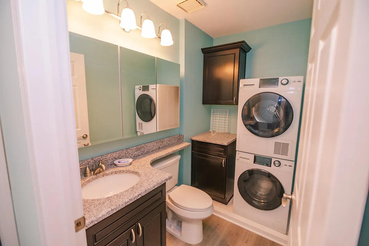 apartment bathroom with stacked washer and dryer