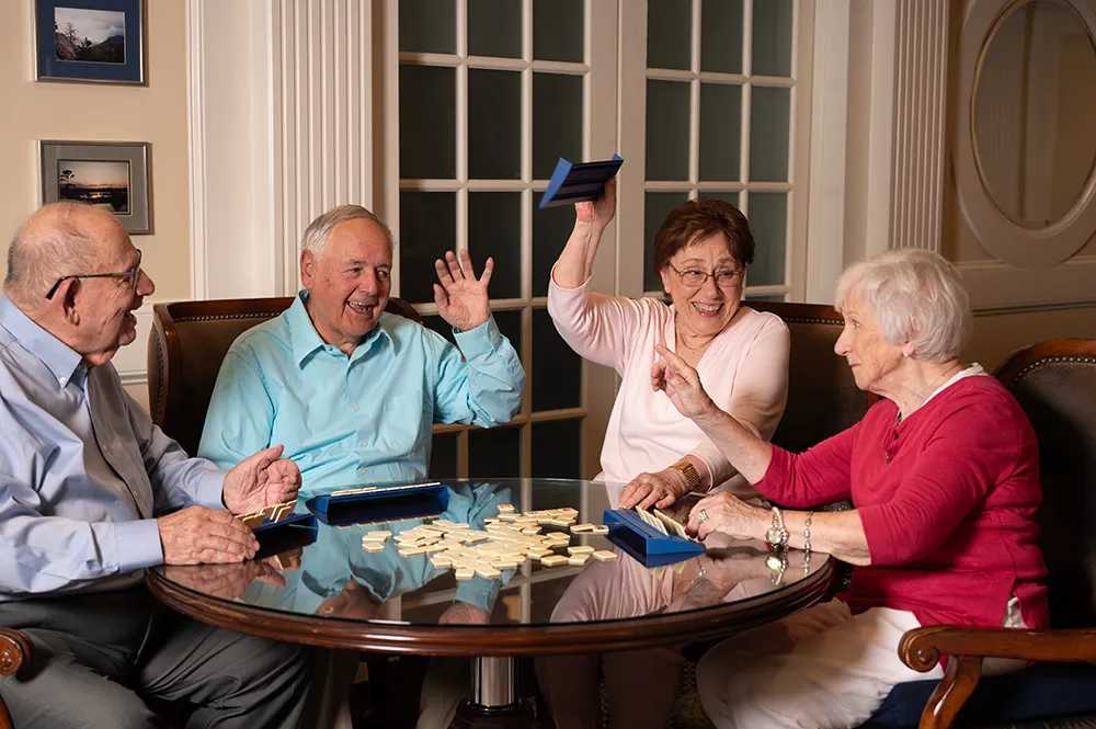 two men and two woman playing a game of scrabble