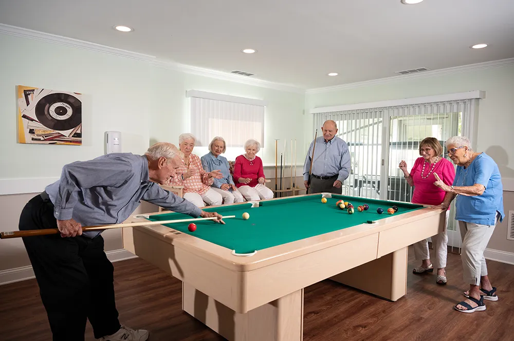 a group of men and women playing pool