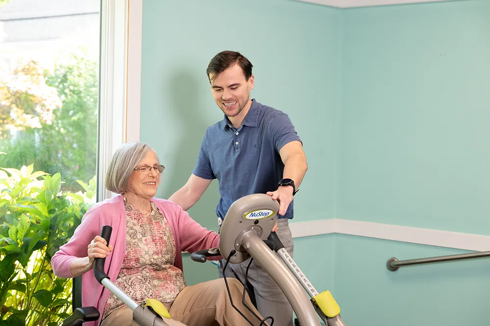 physical therapist helping a women on a piece of equipment