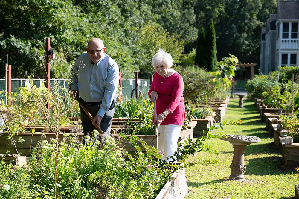 a man and a women gardening in the community garden