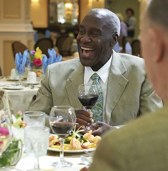 African American gentleman enjoying a glass of wine in the dining room